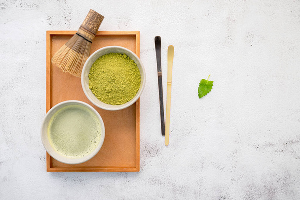 Matcha zöld tea por bambusz matcha habverő ecset beállítása fehér beton háttér . - Fotó, kép