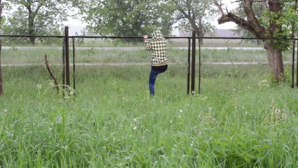 žena stoupání plotem déšť - Záběry, video