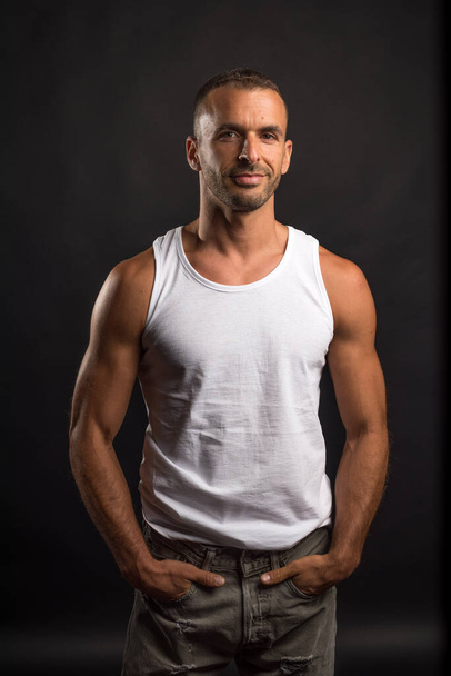 Athletic man in casual clothes. Mid shot. Black background. - Foto, imagen