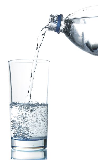 Giet water uit een fles in glas, geïsoleerd op wit - Foto, afbeelding