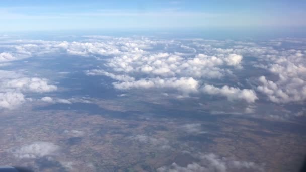Uçan ve pencereden bakan uçakta otururken gökyüzünü, bulutları ve karayı görüyorum. Doğa manzaralı mavi gökyüzü ile özgürlüğü hissetmek ve her zaman yeni bir ilham kaynağı olmak ve rahatlama yolculuğu hissetmek. - Video, Çekim