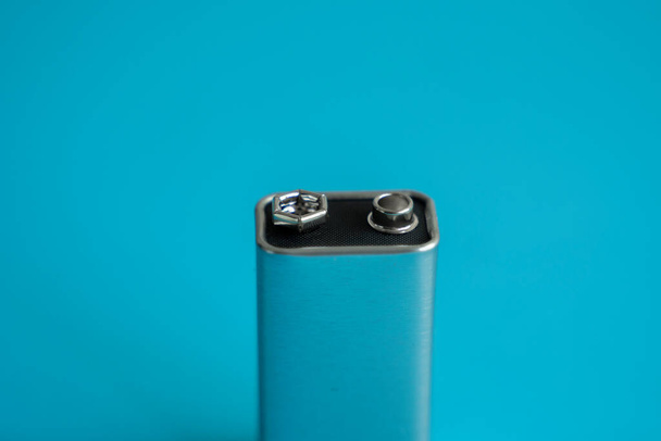 High voltage battery on a blue background. Silver Volt battery. 9V Advanced Lithium Batteries. - Fotó, kép