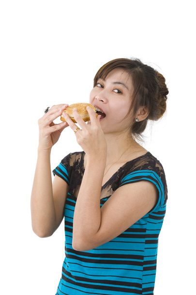 Молода жінка їсть гамбургер
 - Фото, зображення