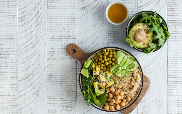 Healthy vegetable lunch from the Buddha bowl with quinoa, avocado, chickpeas, cucumber. The concept of a healthy food dish for vegetarians, a trend dish. High quality photo - Fotó, kép