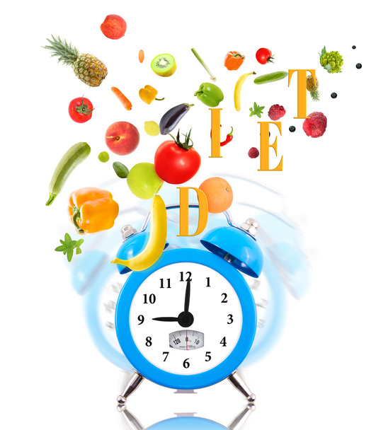 dieet concept met klok, schaal dial, fruit en groenten. - Foto, afbeelding