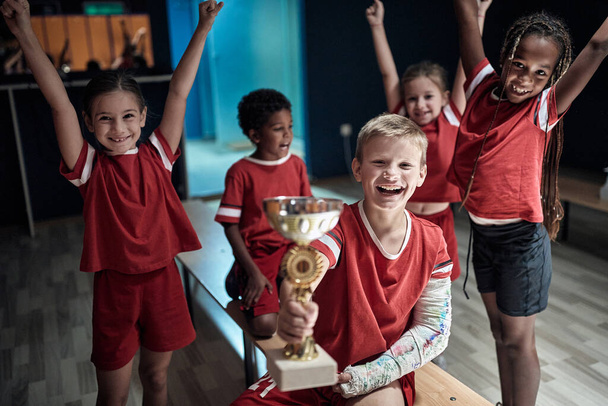 Kid's soccer team in a locker room celebrating the triumph - Photo, image