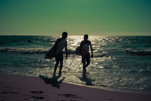Силуэты молодых серферов на море
 - Фото, изображение