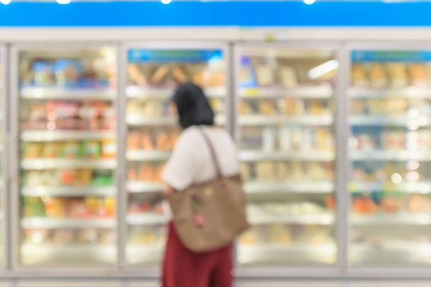 Süpermarket ticari buzdolabı dondurucusu dondurulmuş gıdaları soyut bulanık arkaplanı gösteriyor - Fotoğraf, Görsel