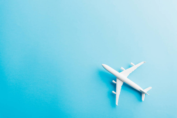 World Tourism Day, Top view flat lay of minimal toy model plane, airplane, studio shot isolated on a blue background, accessory flight holiday concept - Zdjęcie, obraz