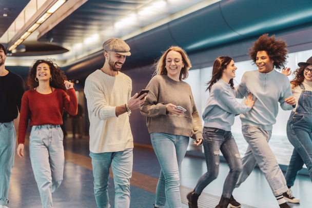 Група молодих друзів розважаються в метро підземного митрополита Щасливі модні люди діляться часом і сміються разом - концепція способу життя молоді тисячоліття дружби
 - Фото, зображення