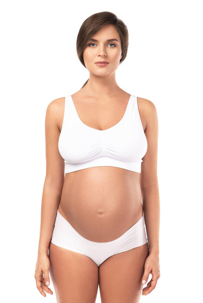 Young and beautiful pregnant woman wearing lingerie on white background - Φωτογραφία, εικόνα