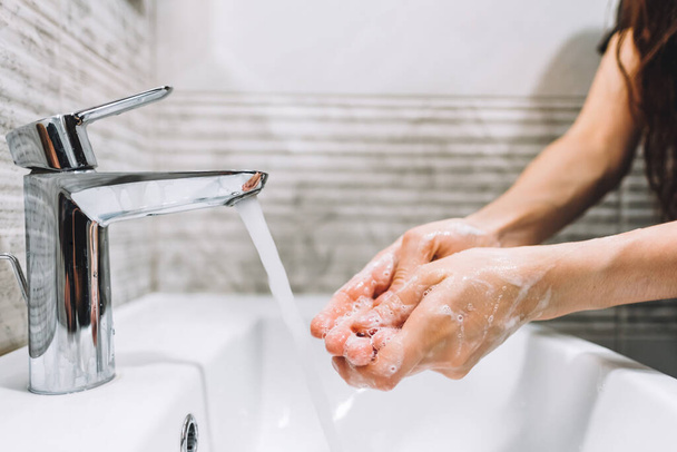 女性はウイルス性疾患、コロナウイルスの予防のための石鹸タップで手を掃除します。衛生概念。高品質の写真 - 写真・画像