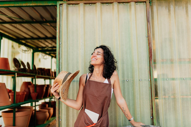 Žena fanoušky sama se svým slamákem na dveřích svého keramického podnikání - Fotografie, Obrázek
