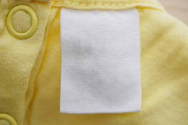 üres fehér ruházat címke sárga szövet textúra háttér - Fotó, kép