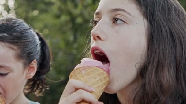 Fiatal lány eszik fagylaltot egy tölcsér, élvezi és nevet - Felvétel, videó