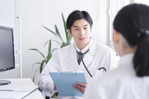 Japonský lékař vyšetřující pracovnici v kanceláři - Fotografie, Obrázek