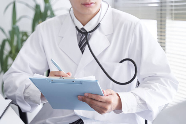 Gros plan d'un médecin japonais examinant un patient. - Photo, image