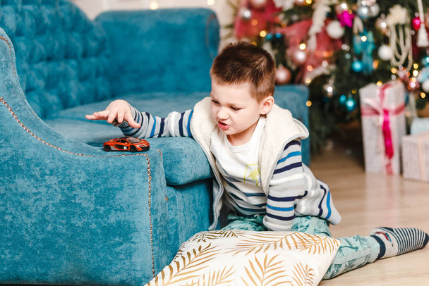 child plays on the couch in the Christmas room - Фото, зображення