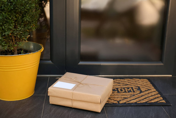 Delivered parcel on door mat near entrance - Fotó, kép