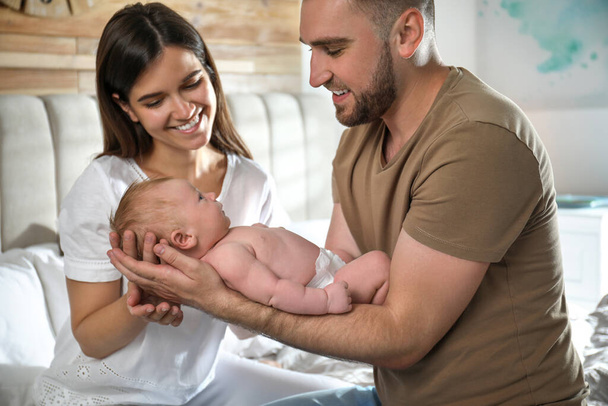 Happy couple with their newborn baby at home - Fotó, kép