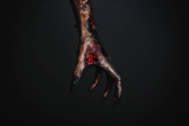 Scary monster on black background, closeup of hand. Halloween character - Foto, Imagem