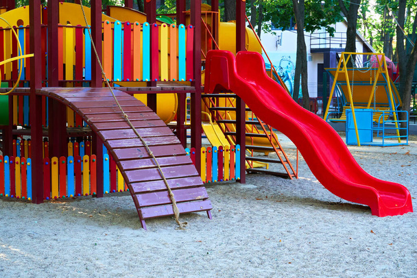 детская площадка в городском парке рано утром, различные качели и карусели - Фото, изображение