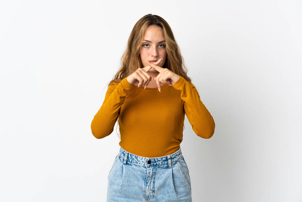 Young blonde woman isolated on blue background showing a sign of silence gesture - Photo, Image
