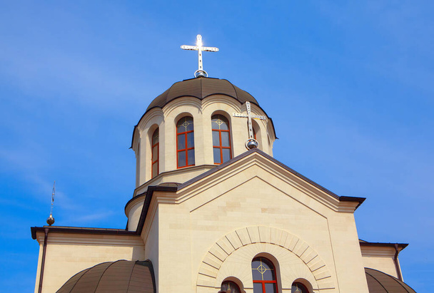 Zilveren kruis op de koepel. Orthodoxe kerk gemaakt van witte steen  - Foto, afbeelding