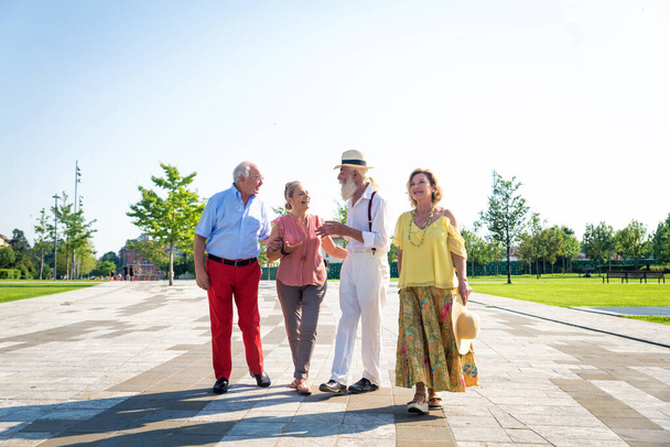 Groupe de jeunes aînés qui s'amusent à l'extérieur - Quatre pensionnés qui se lient à l'extérieur, concepts sur le mode de vie et les personnes âgées - Photo, image