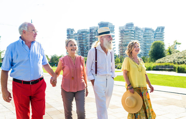 Group of youthful seniors having fun outdoors - Four pensioners bonding outdoors, concepts about lifestyle and elderly - 写真・画像