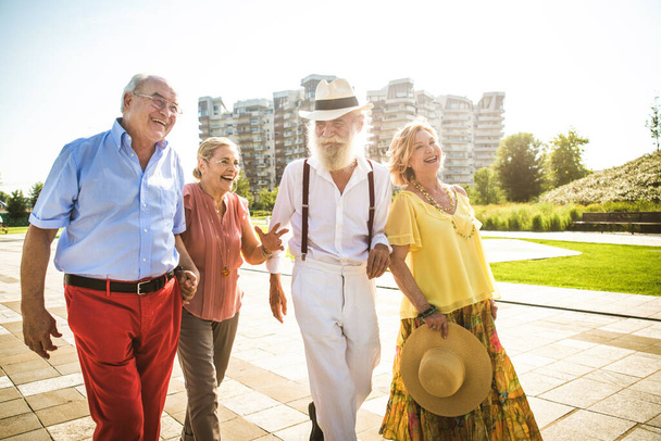 Gruppo di giovani anziani che si divertono all'aperto - Quattro pensionati che legano all'aperto, concetti di stile di vita e anziani - Foto, immagini