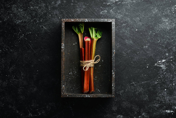 Chopped fresh rhubarb on a black stone background. Top view. Free copy space. - Photo, Image
