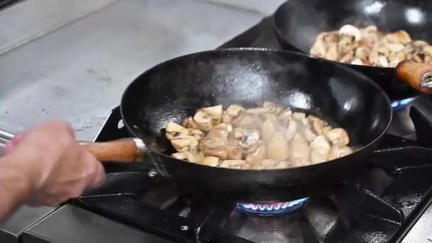 Kuchař vaření houby v pánvi na spalování ohně zpomalení pohybu.  - Záběry, video