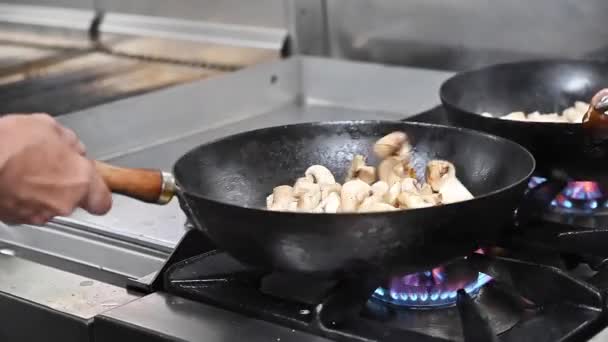Chef cooking mushrooms in frying pan on burning fire slow motion.  - Footage, Video