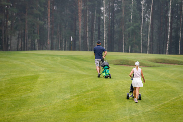 Golfers walk across the field during the tournament - Foto, Imagen