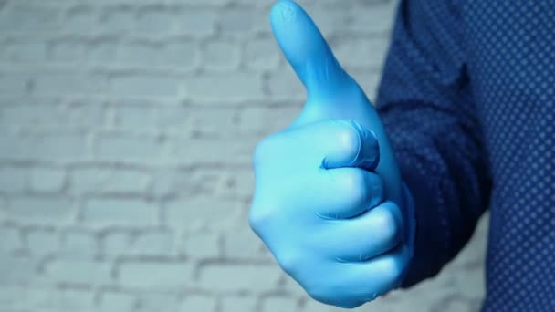 Close-up van personen hand in medische handschoenen tonen een duim-up. - Video