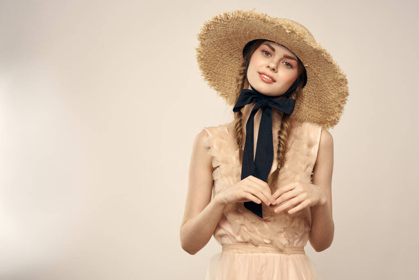 Niza chica en un sombrero de paja con una cinta negra y en un vestido sobre un fondo ligero romance modelo divertido emoción - Foto, Imagen