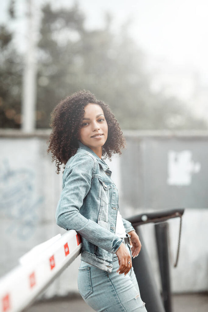 Jeune jolie fille noire se détendre en plein air. Portrait hipster de rue. Femme étudiante à pied - Photo, image