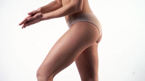 zkušená wellness žena expert aplikuje krém na stehně detailní up - Záběry, video