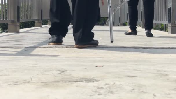 Κοντινό πλάνο του πίσω όψη παπούτσια ηλικιωμένων και δεκανίκι περπάτημα - Πλάνα, βίντεο