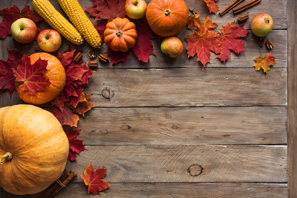Autumn composition - pumpkins, apples, autumn maple leaves, corns  on wooden background, creative flat lay, top view, copy space. Seasonal autumn holiday concept. - Zdjęcie, obraz