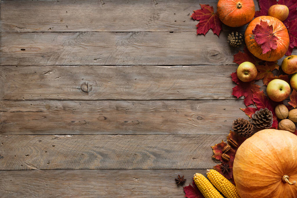 Autumn composition - pumpkins, apples, autumn maple leaves, pine cones  on wooden background, creative flat lay, top view, copy space. Seasonal autumn holiday concept. - Photo, Image