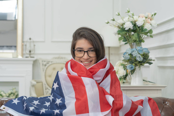 Portrait of smiling brunette woman with USA flag, The United States of America national flag in independence day, Memorial Day, or 4th of July. - Fotó, kép