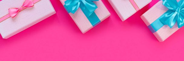 Banner from set of beautiful gift boxes with blue bows on pink background. Holiday sale. Copy space for your text. Flat lay, top view, copy space concept - Фото, изображение