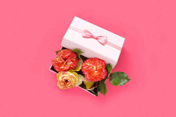 Ramo de hermosas rosas rojas en caja de regalo sobre fondo rosa. Copiar espacio para texto, invitación o felicitaciones - Foto, Imagen