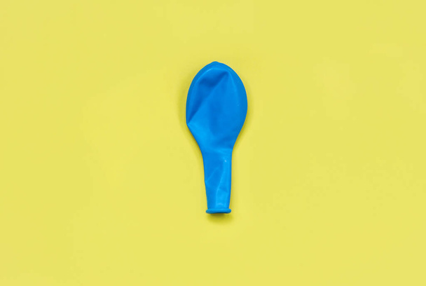 holiday concept, bursting neoplastic blue balloon on a bright yellow background - Photo, Image