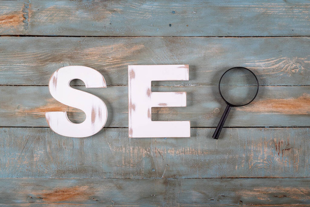 seo word formed with white letters and magnifying glass. Search engine optimization concept. - Fotoğraf, Görsel