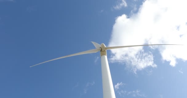 Windkraftanlage an einem sonnigen Tag mit blauem Himmel und Wolken. Ökofeld Windpark. Grüne ökologische Stromerzeugung. - Filmmaterial, Video