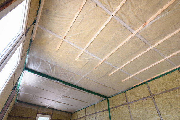 Aislamiento del techo desde el interior con lana mineral en una casa de campo de madera - Foto, Imagen