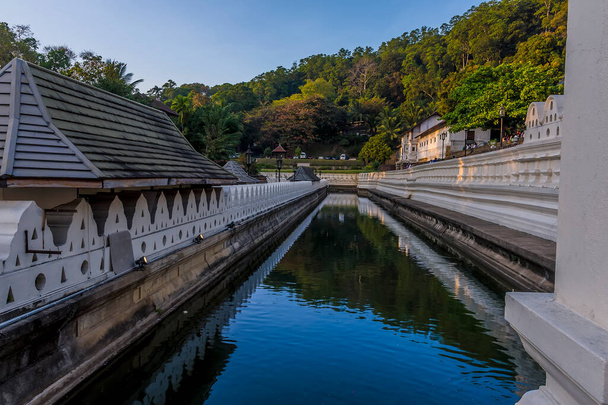 A view at sunset along the moat in front of the Temple of the Sacred Tooth Relic in  Kandy, Sri Lanka, Asia - Fotoğraf, Görsel